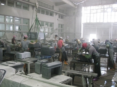 中国の石材加工工場での手動研磨風景