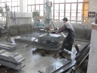 中国の石材加工工場における手動研磨風景