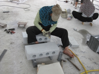 ▲手作業にて「小タタキ」加工をする女性の石職人