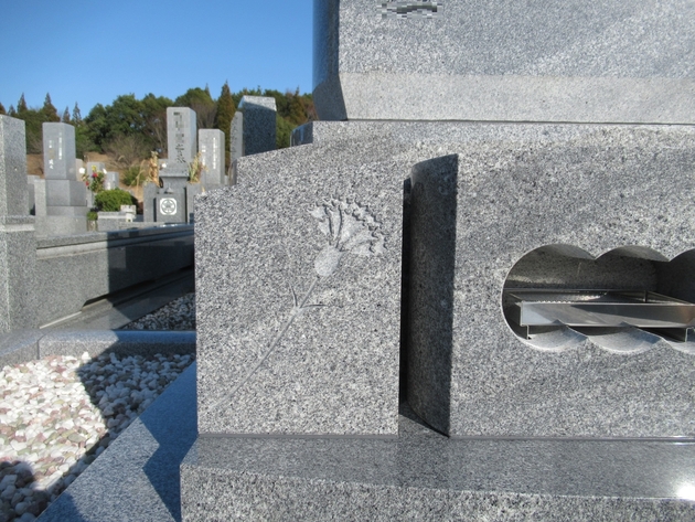 左側の墓石花立には、カーネーションを彫刻。