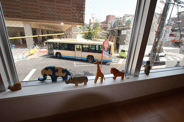 子供の視線に合わせた低い窓からバスが見えます。