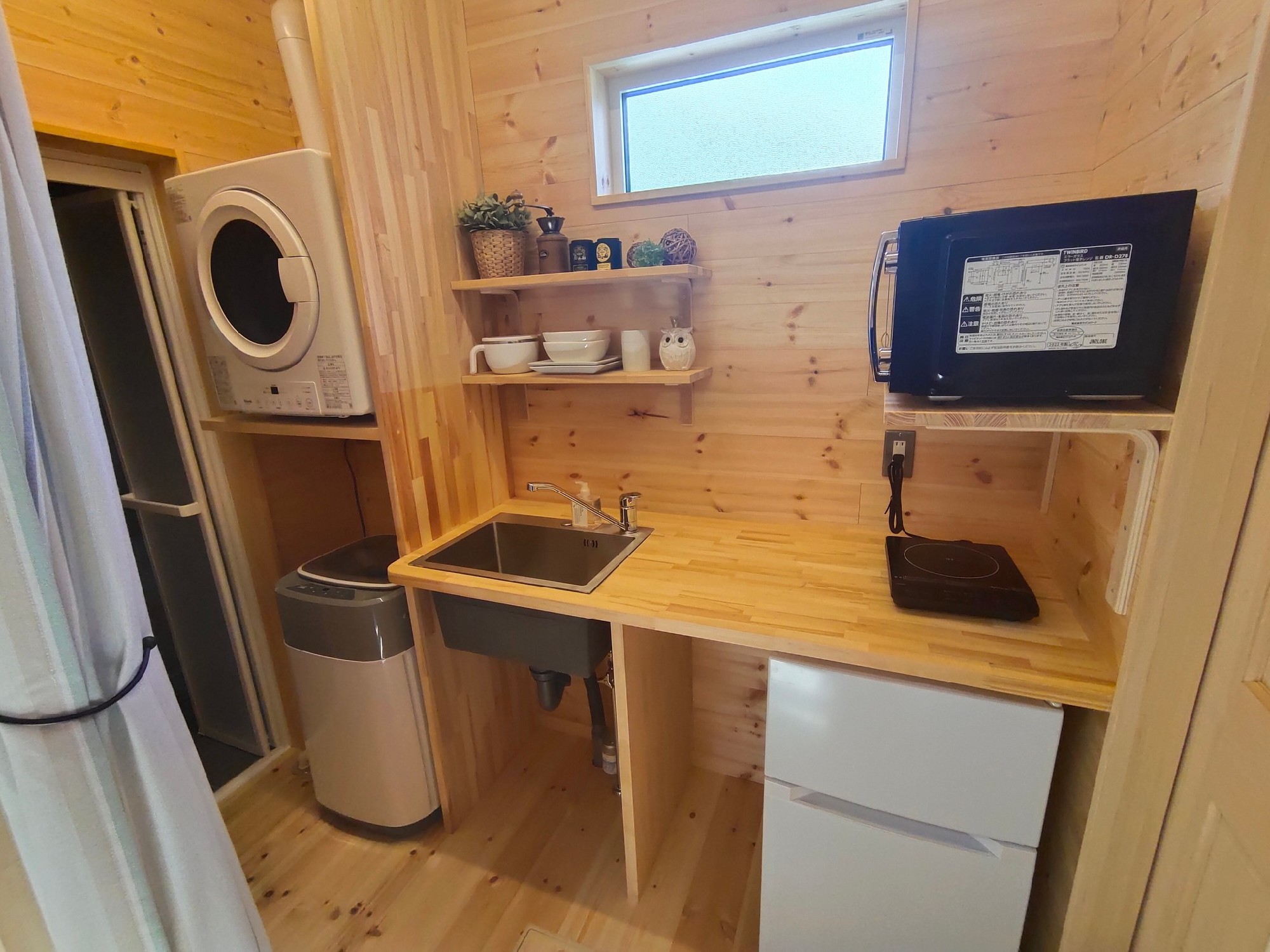 ミニキッチンとその隣に洗濯機とガス乾燥機。