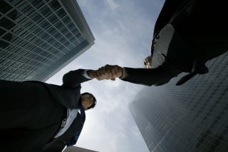 建物と握手をしている二人