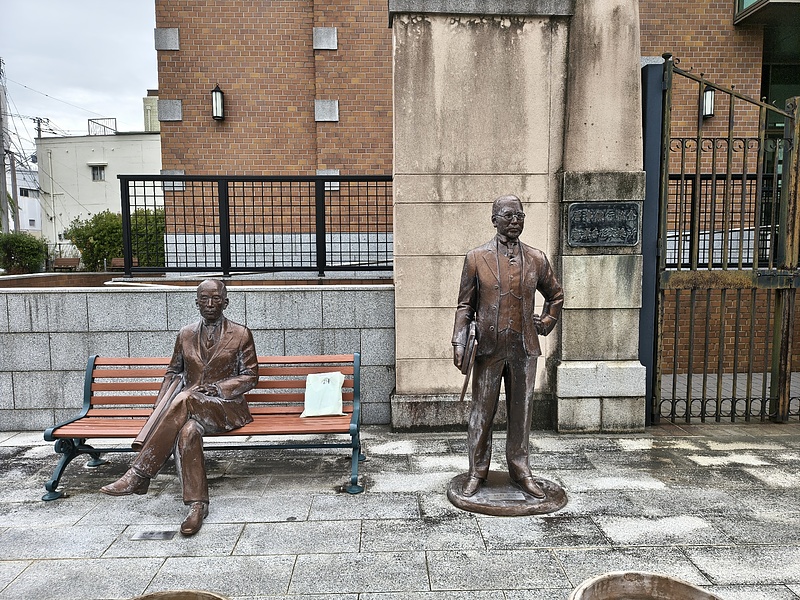 旧唐津銀行本店の横に辰野金吾先生が立っています