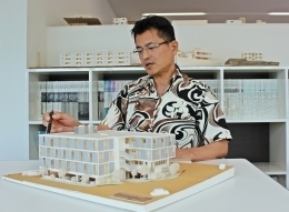 建築模型を手に設計の理念について語る伊良波朝義さん