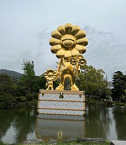 日本庭園の中に巨大な彫刻がそびえ立っています。