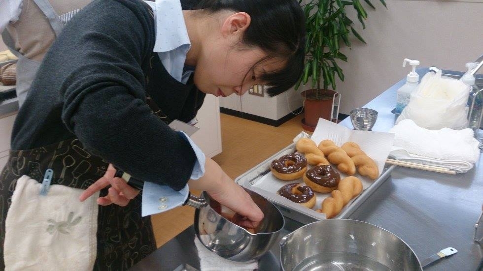 ドーナッツパンにチョコレートをまぶし中